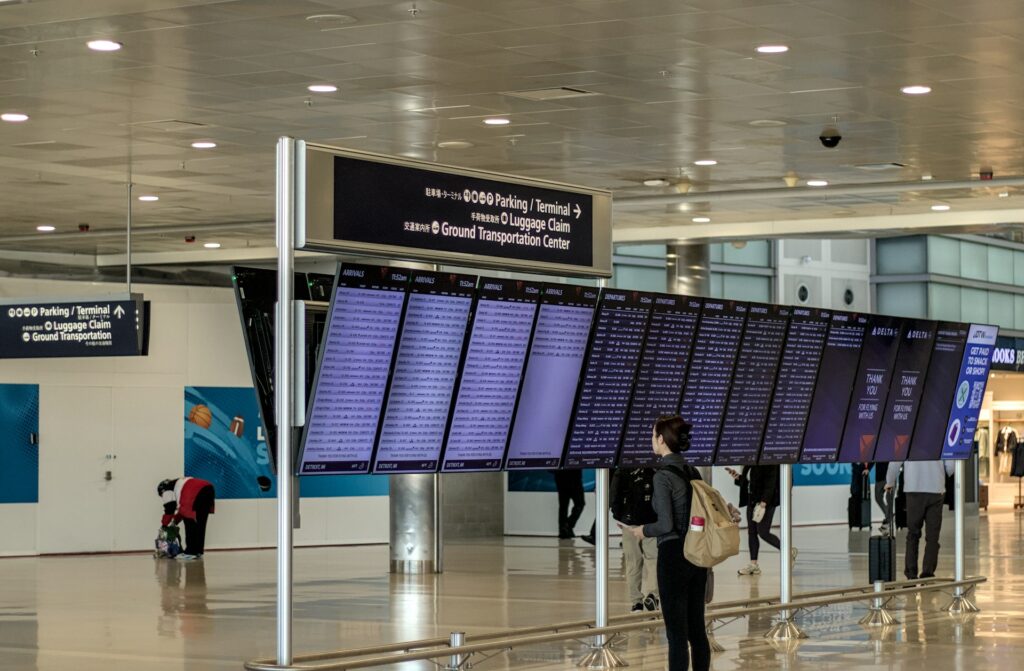 空港の出発案内板を見る旅行者